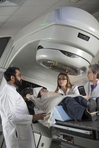 Nirav Kapadia, MD and radiation therapists position a patient at the Varian TrueBeam Linear Accelerator, one of the machines used for radiation therapy.