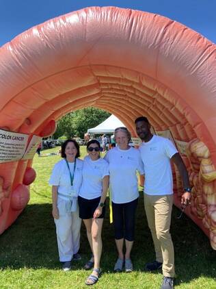 The COE team standing in an inflatable colon