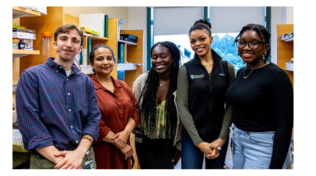 Diverse male and female college age students standing in library