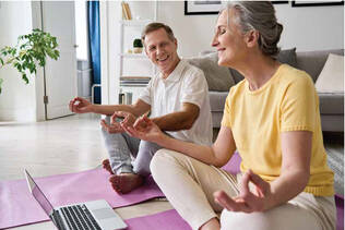 A man and a woman seated on the floor in yoga poses