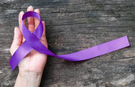 Purple awareness ribbon on a hand