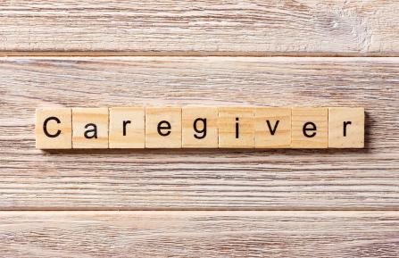 Word caregiver spelled out on Scrabble tiles