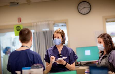 Joanne Conroy, MD takes notes during visit to COVID-19 Unit