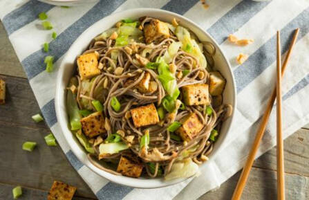 Bowl of Sichuan tan tan noodles with chopsticks to the side of the bowl