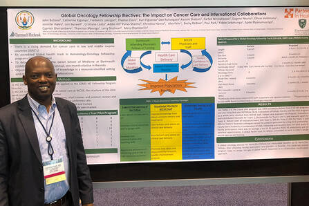 A doctor stands in front of a large, colorful poster entitled "Global Oncology Fellowship Electives: The Impact on Cancer Care and International Collaborations"