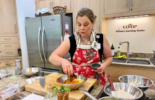 Elise Cushman chopping vegetables in the test kitchen at the Food Coop in Lebanon, NH