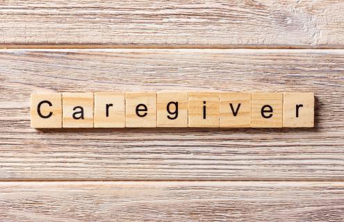 Word caregiver spelled out on Scrabble tiles