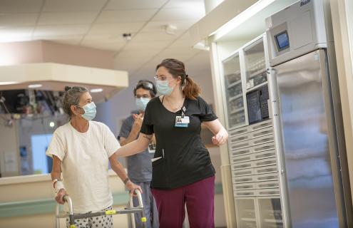 Photo of women walking down a hallway with helper.