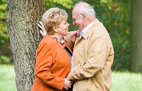 An older couple about to kiss
